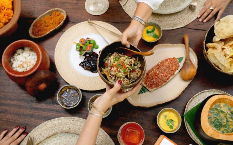 People sharing several dishes at The Long Table Restaurant and Bar in Seminyak, Bali.