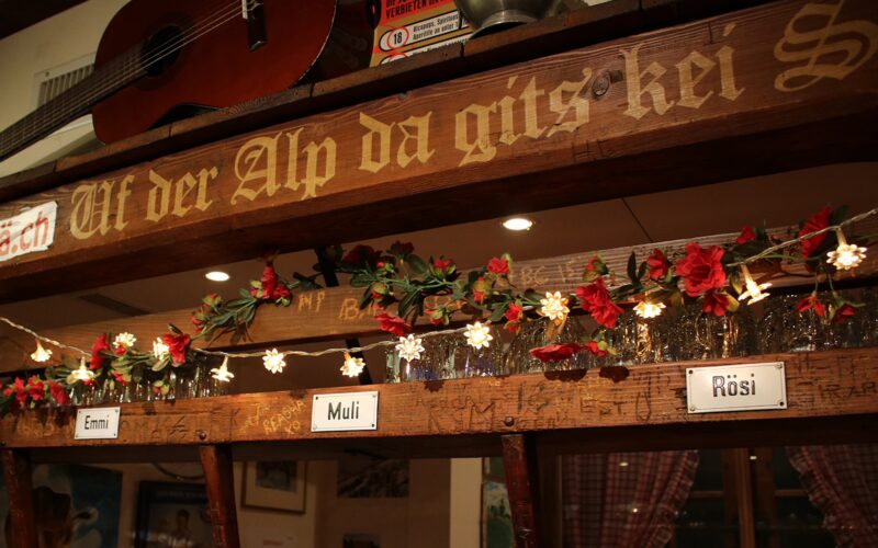 Warm timber-panelled interior of &Auml;lpli Bar in Zurich, with wooden tables and traditional d&eacute;cor.