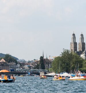 Passengers taking in views of Lake Zurich and the surrounding landscape from a cruise boat.